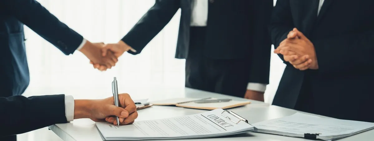 Sócios assinando contrato social de empresa LTDA em reunião de negócios Sócios assinando contrato social de empresa LTDA em reunião de negócios